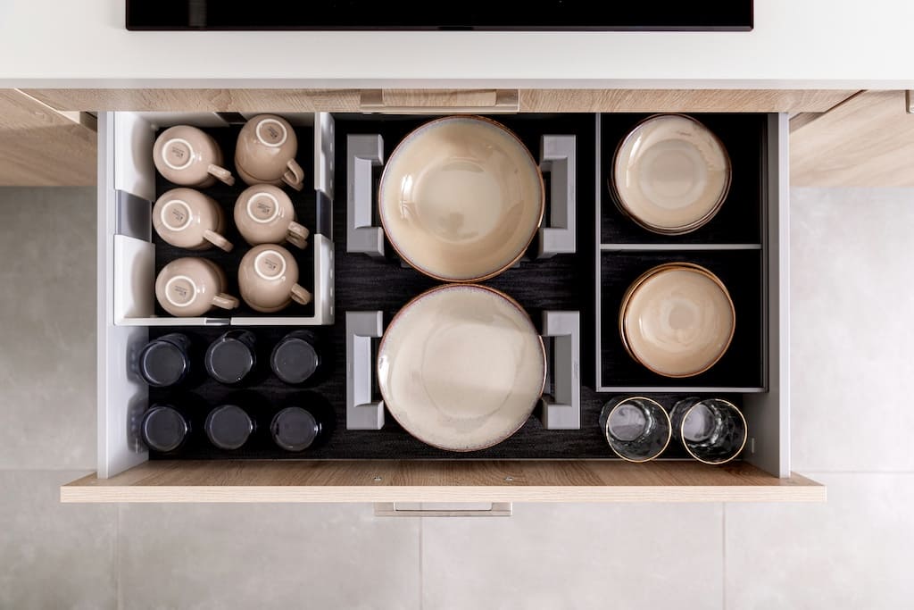Tiroir de cuisine avec casseroles et poêles rangées verticalement pour optimiser l'espace