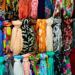 Collection de foulards colorés rangés sur porte-accessoires organisation visible par motifs et couleurs