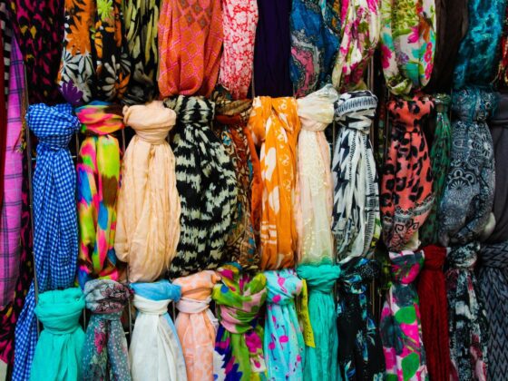 Collection de foulards colorés rangés sur porte-accessoires organisation visible par motifs et couleurs