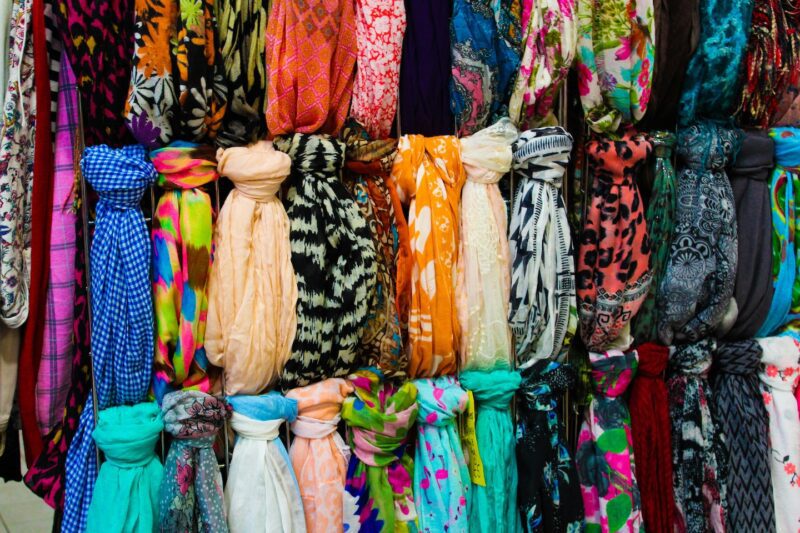Collection de foulards colorés rangés sur porte-accessoires organisation visible par motifs et couleurs