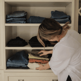 Femme pliant ses vêtements selon la méthode KonMari dans sa chambre lumineuse