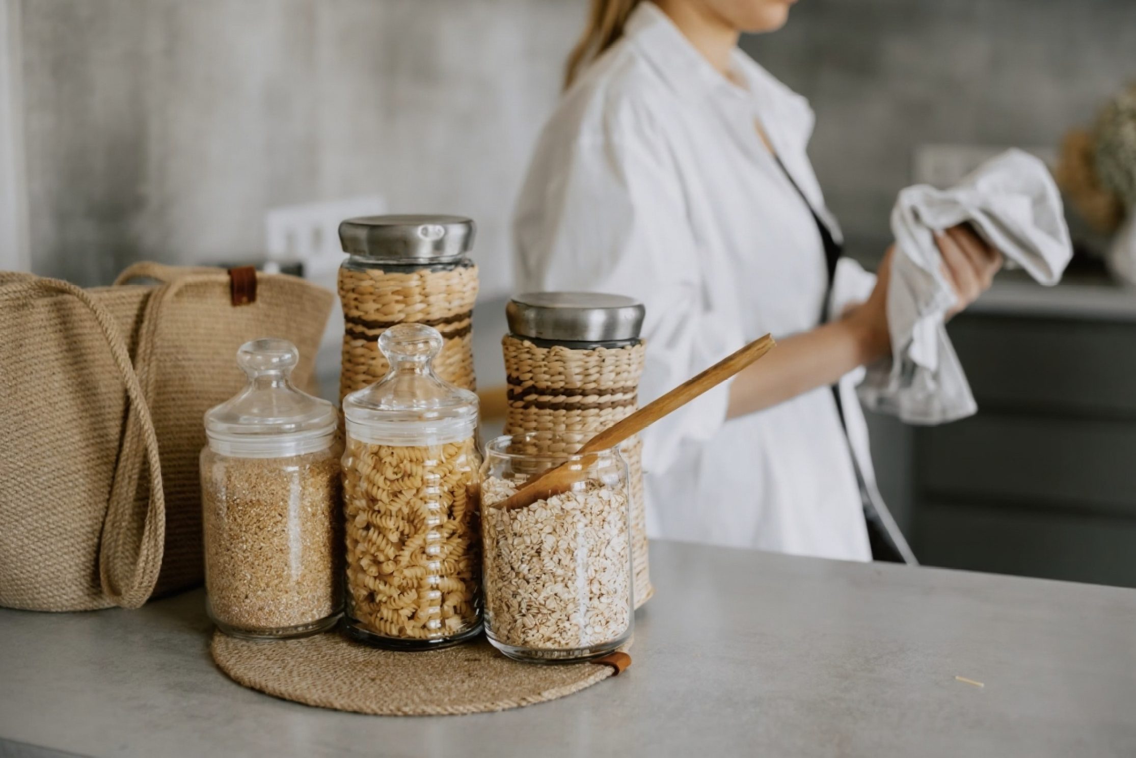 Cuisine organisée avec bocaux hermétiques transparents contenant pâtes riz céréales sur plan de travail