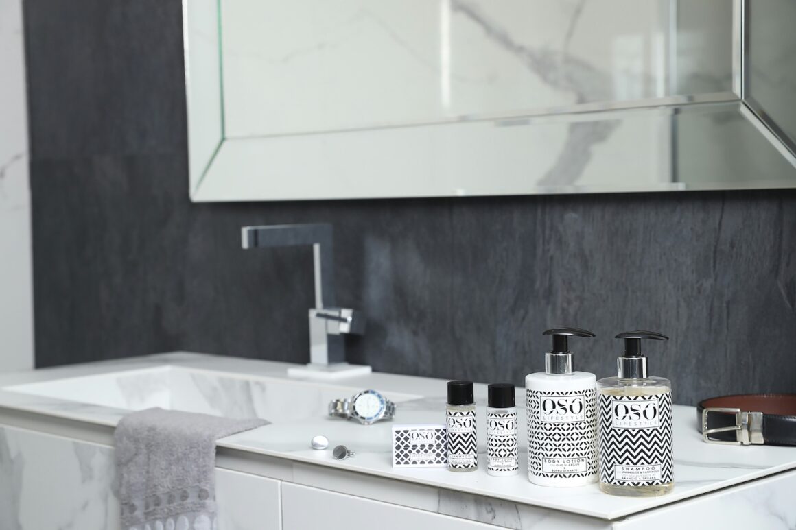 Lavabo de salle de bain propre avec quelques produits bien rangés et serviette blanche pliée